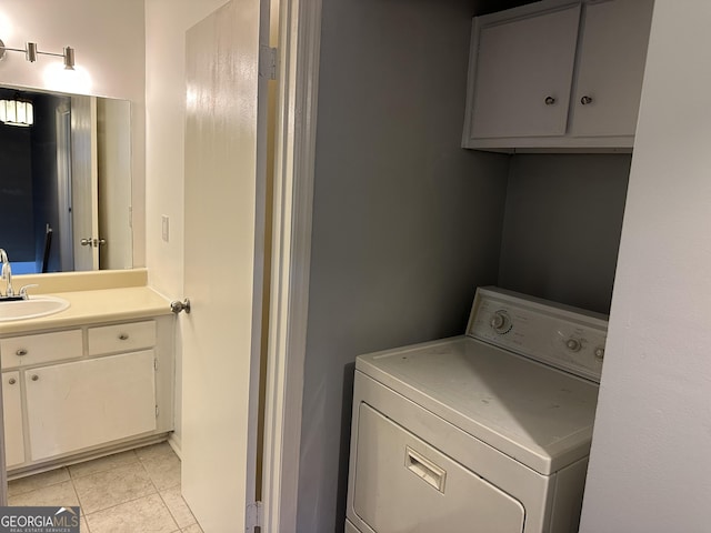 clothes washing area with washer / clothes dryer, light tile patterned flooring, a sink, and laundry area