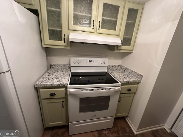 kitchen featuring baseboards, white appliances, glass insert cabinets, and under cabinet range hood