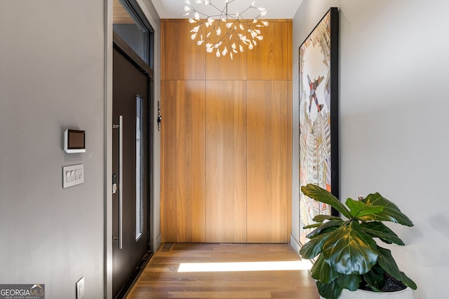 hallway with a chandelier and wood finished floors