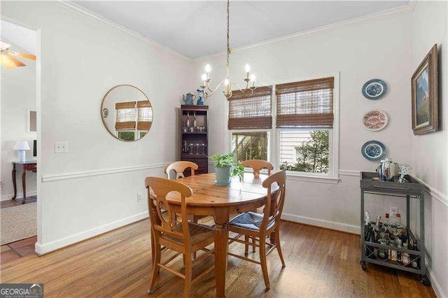 dining space featuring hardwood / wood-style flooring, a chandelier, and crown molding