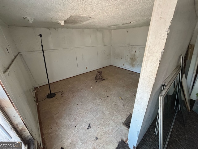basement featuring a textured ceiling