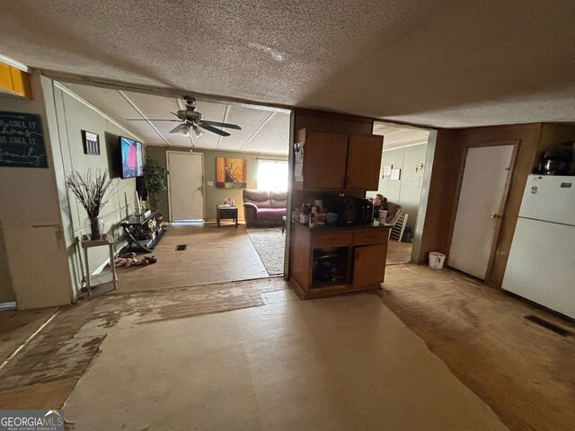 kitchen with ceiling fan, white refrigerator, and a textured ceiling