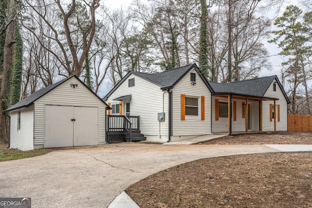 view of property exterior with a porch and an outbuilding