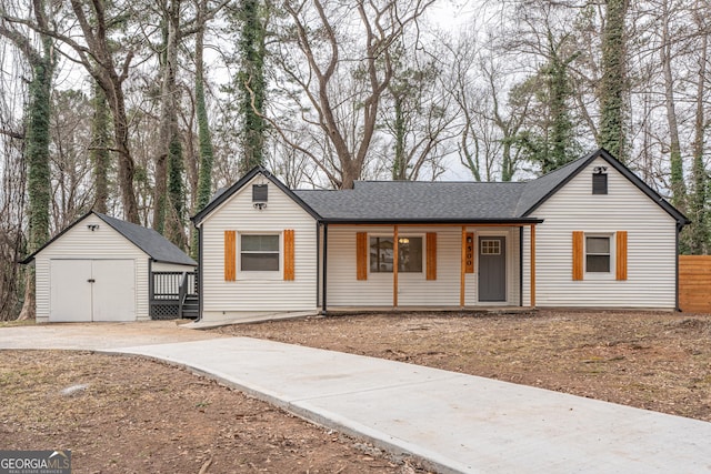 ranch-style home featuring covered porch and an outbuilding