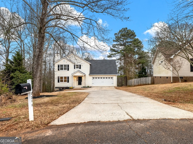 traditional-style home with an attached garage, fence, driveway, roof with shingles, and a front yard