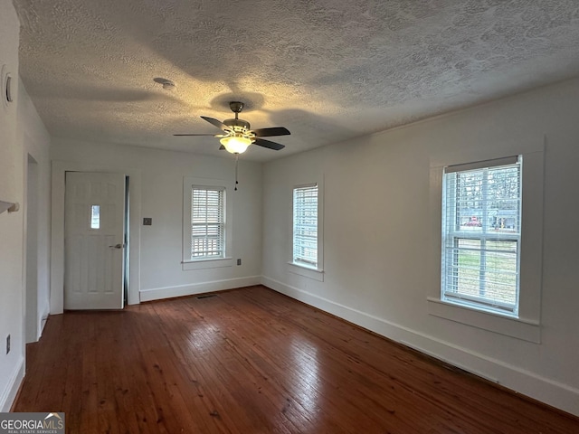 foyer entrance with dark wood-style flooring, visible vents, a ceiling fan, a textured ceiling, and baseboards