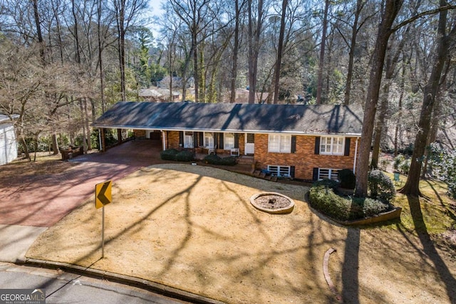 ranch-style home with covered porch and a carport