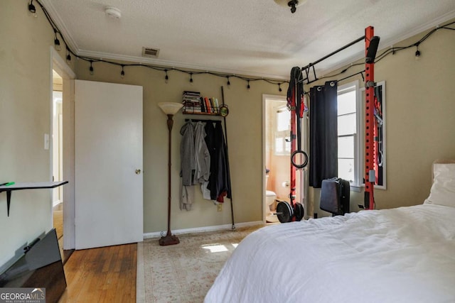 bedroom with a textured ceiling and hardwood / wood-style floors