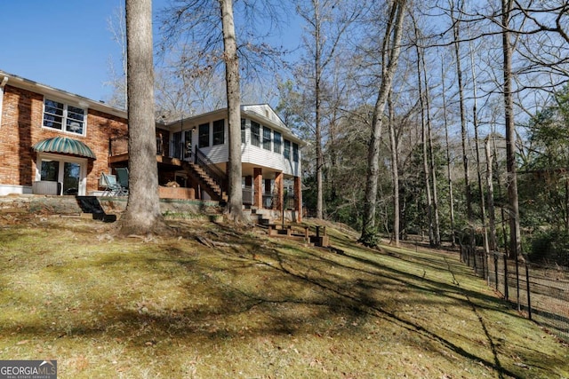 back of house with a yard and a sunroom