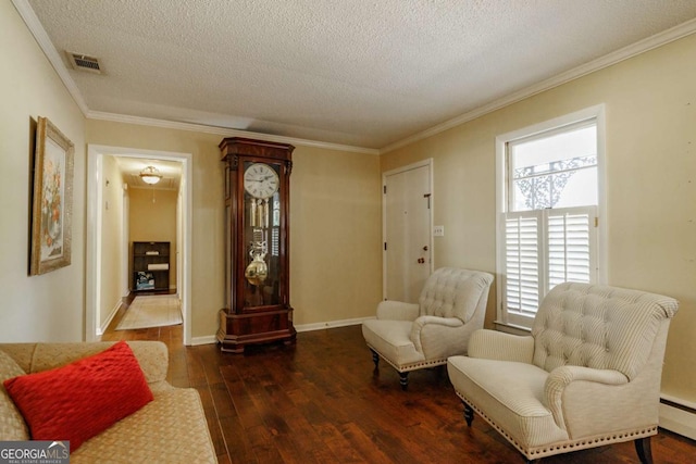 sitting room with a textured ceiling, dark hardwood / wood-style flooring, a baseboard heating unit, and ornamental molding