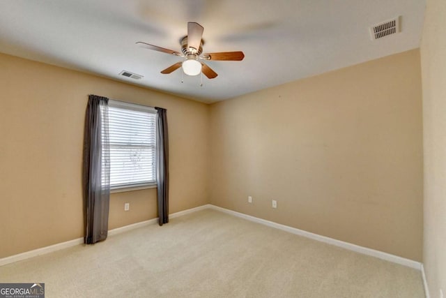 carpeted spare room featuring ceiling fan