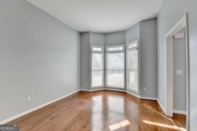 unfurnished room with hardwood / wood-style flooring