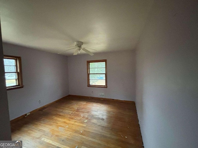 empty room with ceiling fan and light hardwood / wood-style flooring