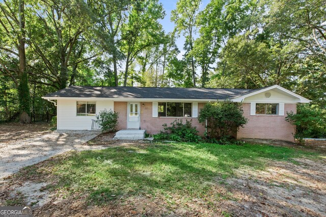 single story home featuring a front yard and brick siding