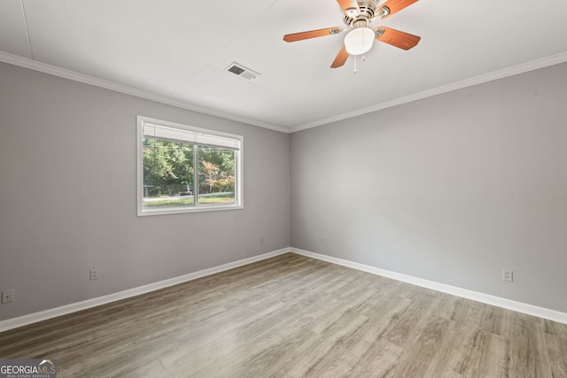 unfurnished room with crown molding, visible vents, ceiling fan, wood finished floors, and baseboards