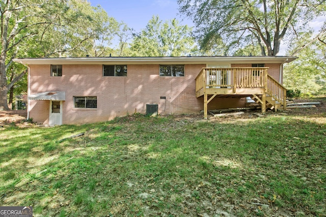 rear view of property featuring crawl space, brick siding, a yard, and a wooden deck