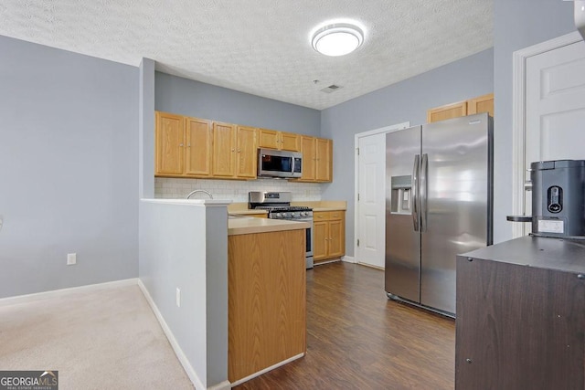 kitchen with baseboards, visible vents, dark wood-type flooring, appliances with stainless steel finishes, and backsplash