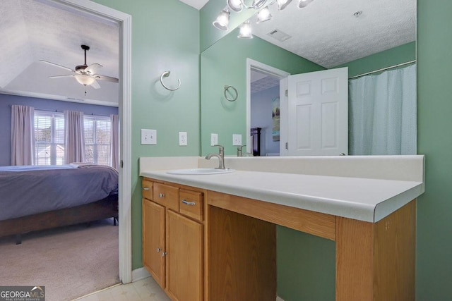 ensuite bathroom with vanity, a ceiling fan, visible vents, a textured ceiling, and connected bathroom