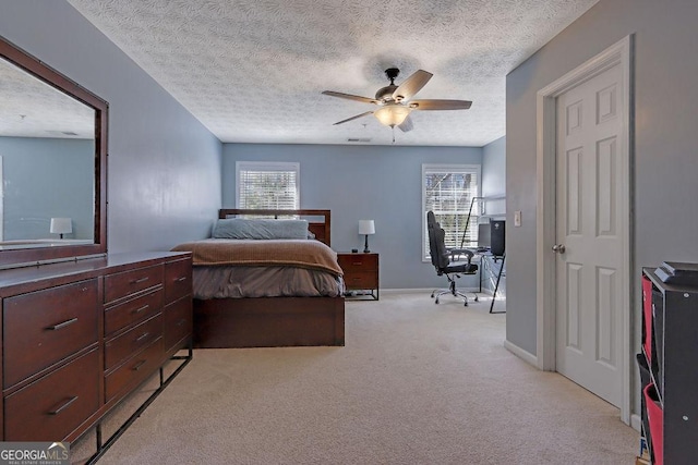 bedroom featuring a ceiling fan, visible vents, baseboards, a textured ceiling, and light carpet