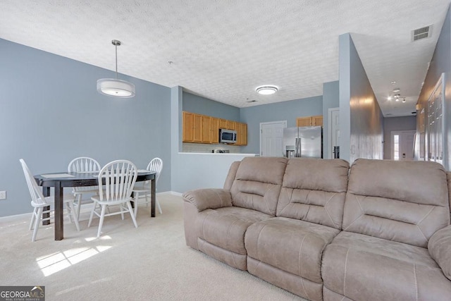 living room with light carpet, visible vents, a textured ceiling, and baseboards