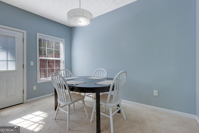 dining space with light colored carpet and baseboards