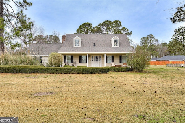 cape cod house featuring a front yard