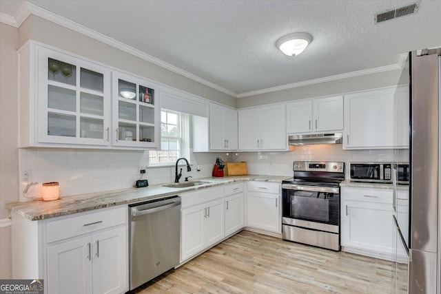 kitchen featuring sink, stainless steel appliances, white cabinetry, and light stone countertops