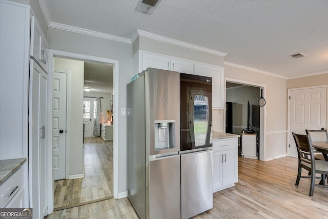 kitchen featuring white cabinetry, light stone countertops, stainless steel fridge, and light hardwood / wood-style flooring