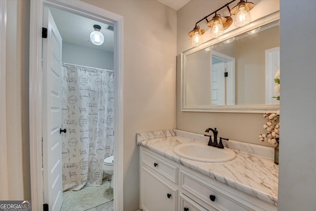 bathroom with toilet, a textured ceiling, curtained shower, and vanity