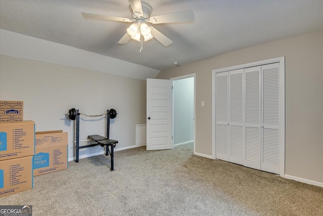 carpeted bedroom featuring ceiling fan, vaulted ceiling, a textured ceiling, and a closet