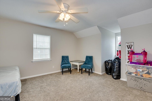 living area featuring lofted ceiling, light colored carpet, and a healthy amount of sunlight