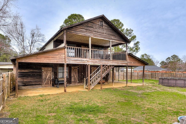 rear view of house with a yard and a fenced in pool