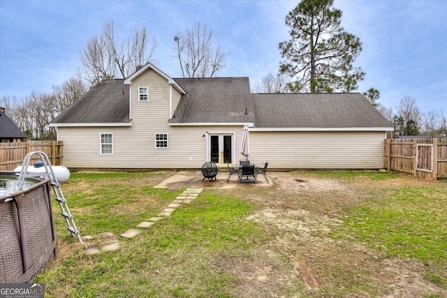 rear view of property with a yard, a patio, an outdoor fire pit, and french doors