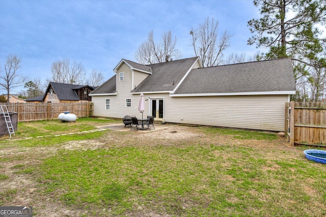 rear view of property with a yard and a patio area