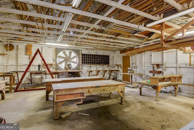 miscellaneous room featuring a workshop area and concrete flooring