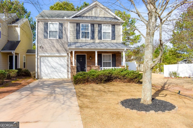 craftsman-style home featuring covered porch, a garage, fence, concrete driveway, and a standing seam roof