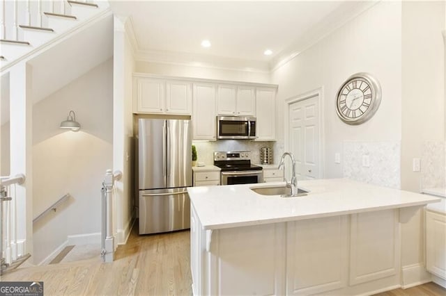 kitchen with sink, kitchen peninsula, appliances with stainless steel finishes, and white cabinets