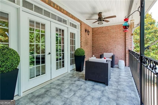 view of patio featuring french doors, ceiling fan, and a balcony