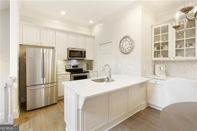 kitchen featuring sink, kitchen peninsula, appliances with stainless steel finishes, and white cabinetry