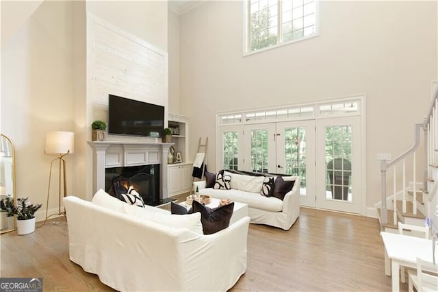 living room featuring light wood-type flooring and a high ceiling