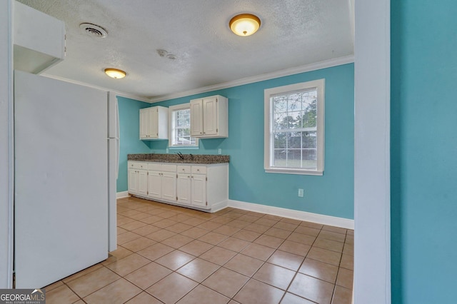 107 Overland Trl, Savannah, GA 31419 - kitchen with freestanding refrigerator, white cabinetry, ornamental molding, a textured ceiling, and healthy amount of natural light