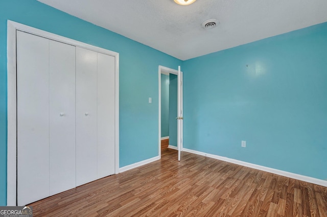 107 Overland Trl, Savannah, GA 31419 - unfurnished bedroom featuring wood finished floors, a closet, and a textured ceiling
