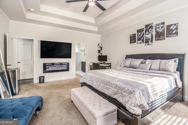 224 Jester Ct, Mcdonough, GA 30252 - carpeted bedroom with baseboards, a glass covered fireplace, ornamental molding, a tray ceiling, and ensuite bath