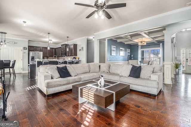 living room featuring ceiling fan with notable chandelier, dark wood-style flooring, coffered ceiling, beam ceiling, and crown molding