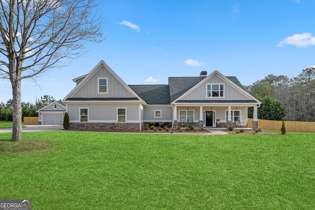 craftsman house with stone siding, a front lawn, and board and batten siding