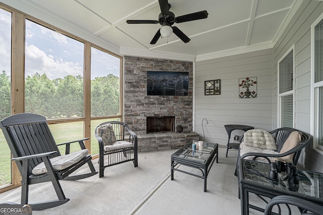 sunroom featuring ceiling fan and a fireplace