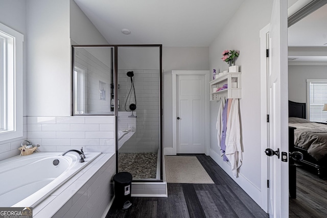 ensuite bathroom with a garden tub, a stall shower, wood finished floors, and connected bathroom