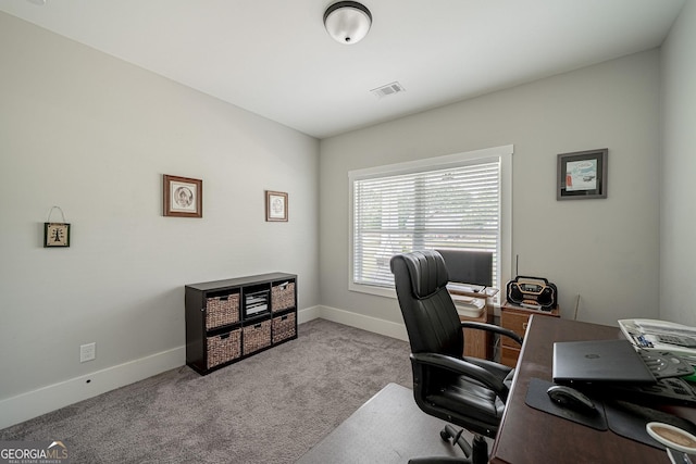 office space with visible vents, light carpet, and baseboards