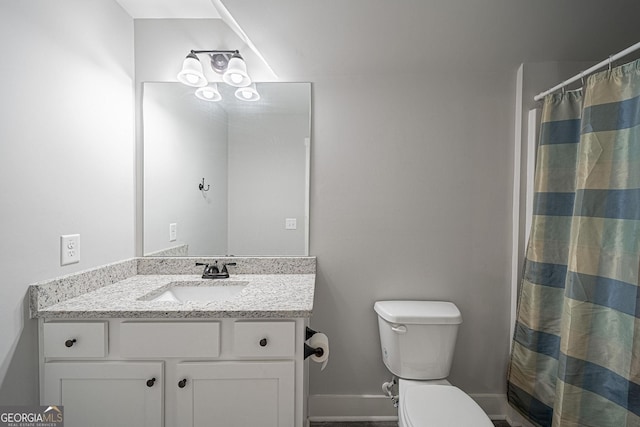 bathroom with baseboards, vanity, toilet, and a shower with curtain