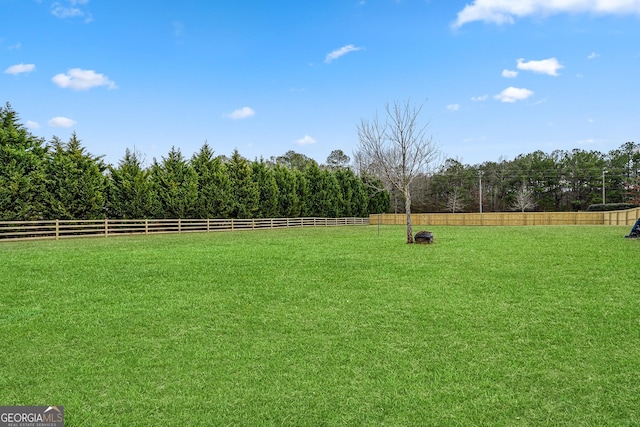 view of yard with a rural view and fence